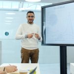 Professional delivering a business presentation with charts in a modern office setting.