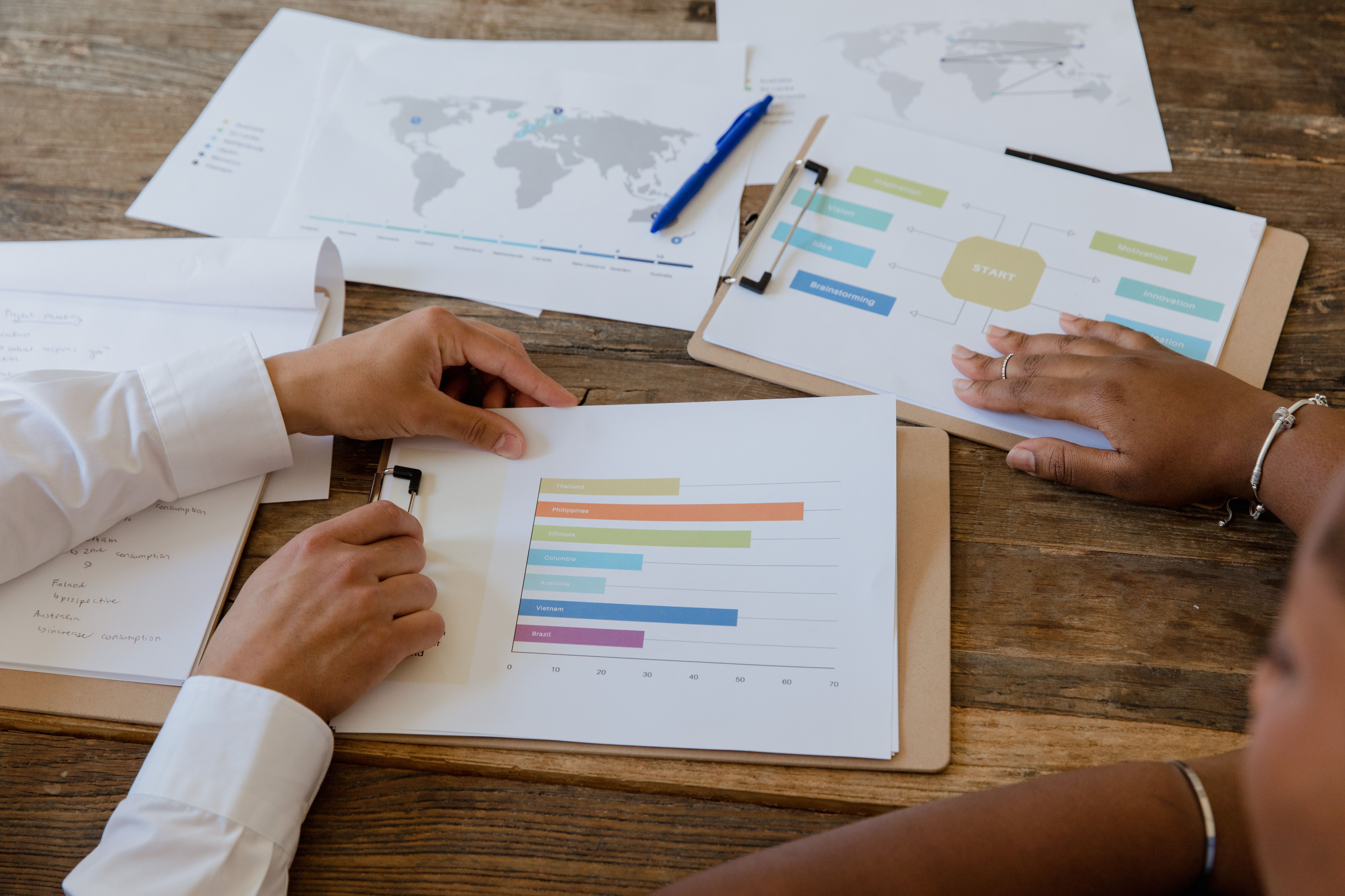 Colleagues discussing charts and graphs on a table during a business meeting.